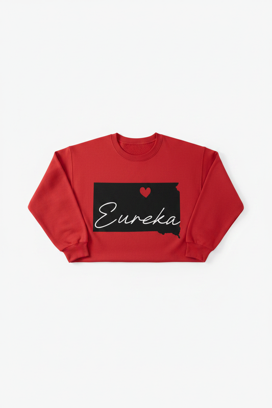 Red crewneck sweatshirt with black South Dakota state silhouette, red heart, and white Eureka cursive script